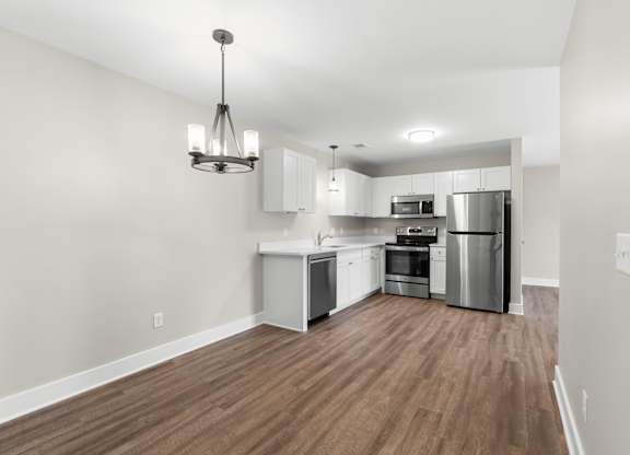 A kitchen with wooden floors and stainless steel appliances.