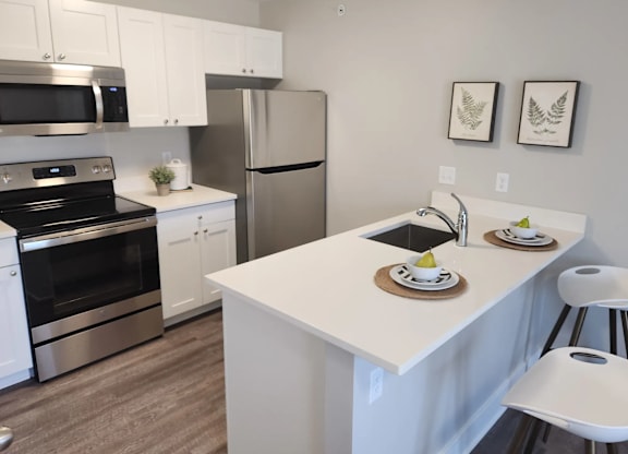 A modern kitchen with a white island and stainless steel appliances.