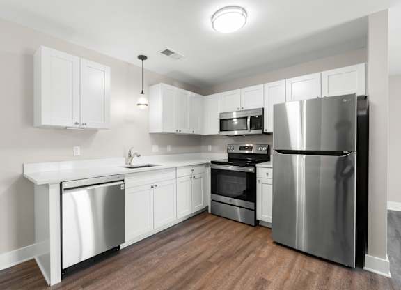 A modern kitchen with stainless steel appliances and white cabinets.