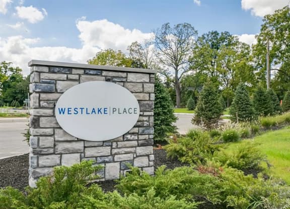 A sign that says Westlake Place in front of a grassy area.