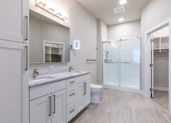 A white bathroom with a walk in shower.