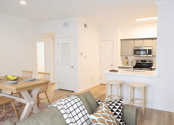 A kitchen with a breakfast bar and a dining table with chairs.