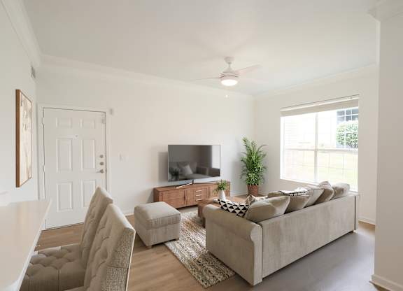 A living room with a couch, chair, and television.