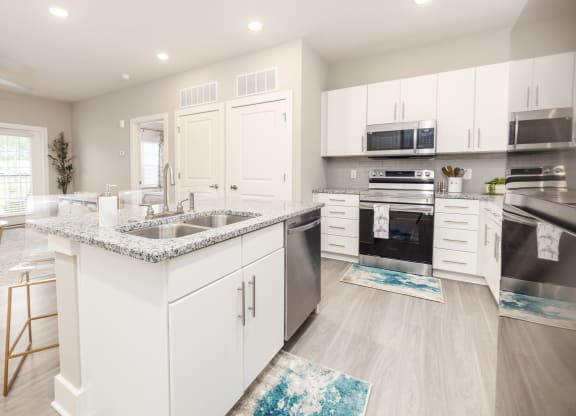 a kitchen with white cabinets and stainless steel appliances