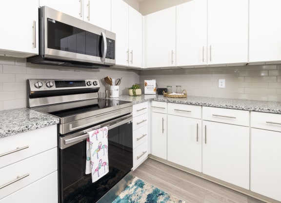 a modern kitchen with white cabinets and stainless steel appliances