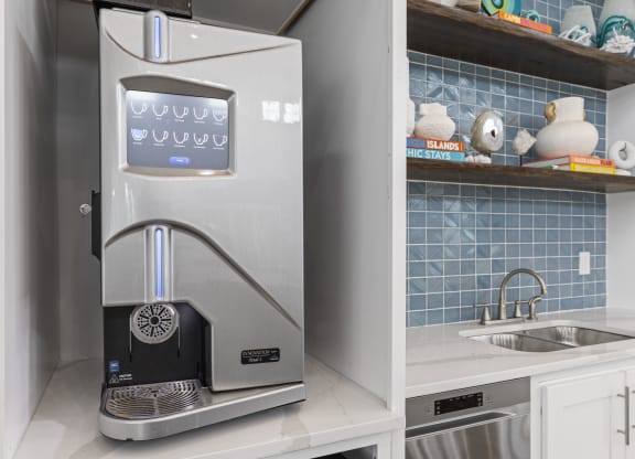 a small kitchen with a coffee machine and a sink