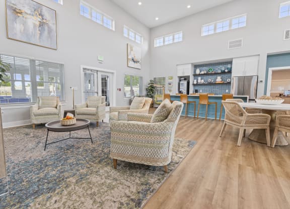 a living room with couches and chairs and a kitchen with a table