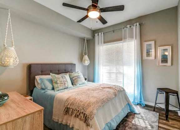 a bedroom with a bed and a ceiling fan