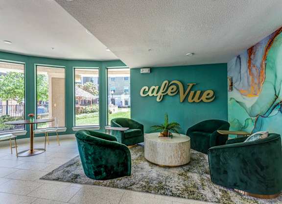 a lobby with green chairs and a green wall with the words café vue on it