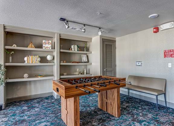 a room with a foosball table and a bench