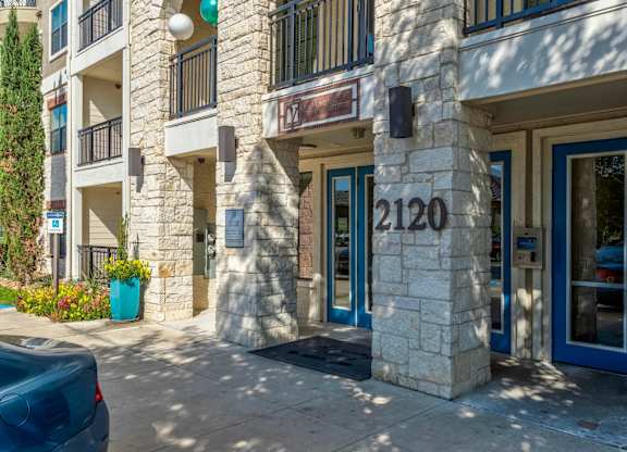 a building with a blue door and a stone facade with the number 2100 on it