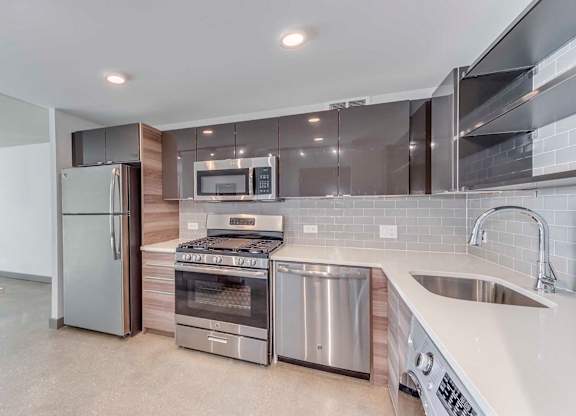 A modern kitchen with stainless steel appliances and a large island.