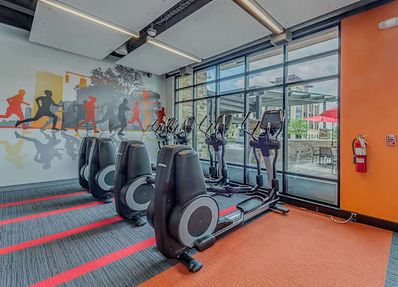 A gym with treadmills and a fire extinguisher.