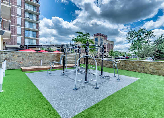 A playground with a green surface and a grey area in the middle.