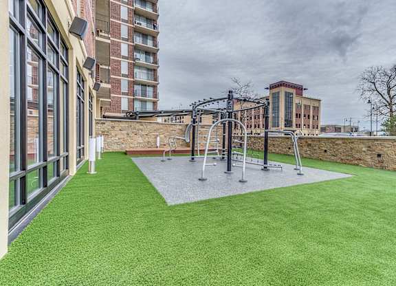 A playground with a swing set and a green lawn.