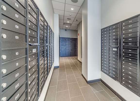 A hallway with a row of mailboxes on the left and right side.