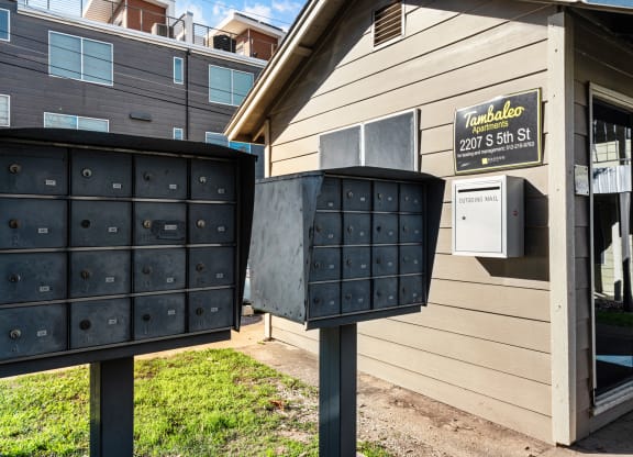two mailboxes in front of a house with a mail truck