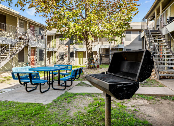 our apartments have a backyard with a grill and a picnic table