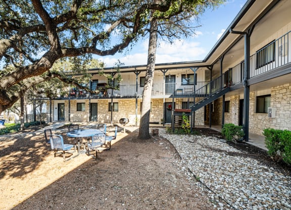 a courtyard with a table and chairs in front of a building