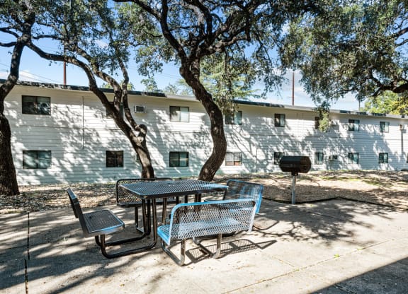 a patio with a table and chairs in front of a building