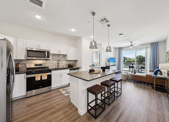 A modern kitchen with a large island and stainless steel appliances.at Fora Apartments, Las Vegas Nevada