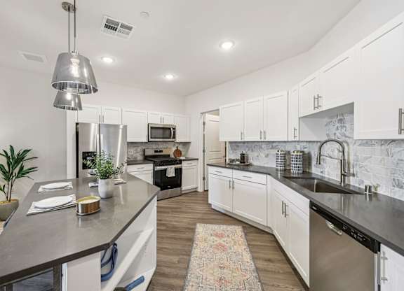 A modern kitchen with a large island and stainless steel appliances.at Fora Apartments, Las Vegas, NV 89183