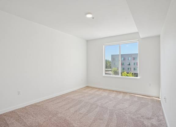 Bedroom with oversized window at Hana Apartments, Hillsboro, Oregon