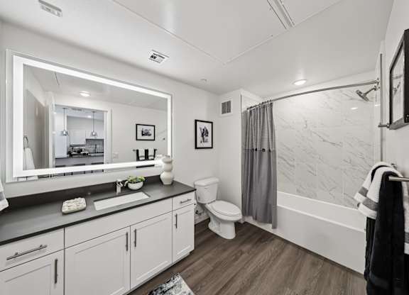 A bathroom with a white sink and a large mirror.at Fora Apartments, Las Vegas, NV 89183