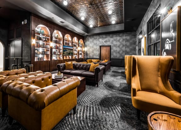 a lounge area with couches and chairs and a wall filled with shelves