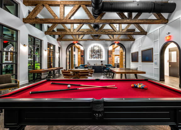 a pool table in the lobby of a building with a lounge area and a large at The Alibi at Lake Lilly, Ocoee, FL, 34761