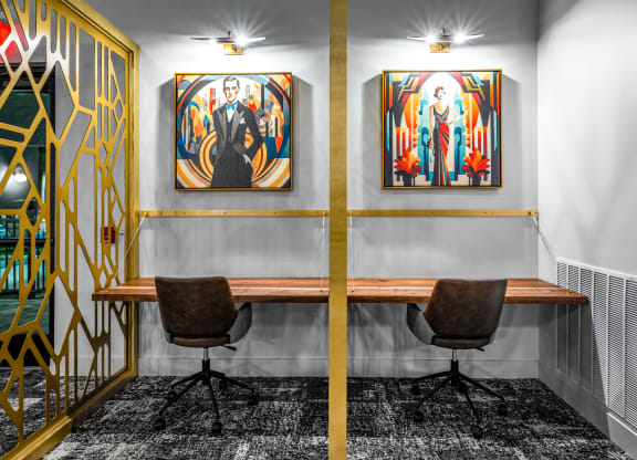 a conference room with two paintings on the wall and a wooden desk