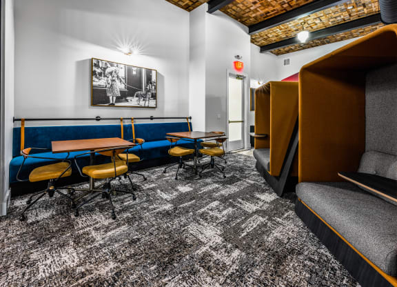 a lounge area with tables and chairs and a television