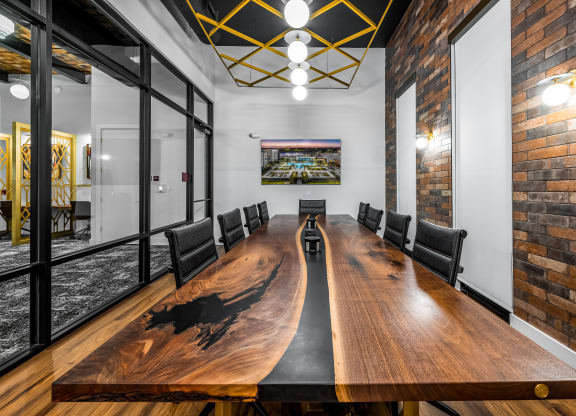 a conference room with a long wooden conference table and brick walls