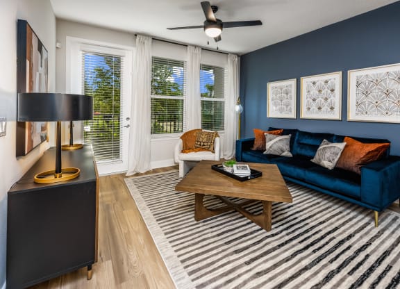 a living room with a blue couch and a wooden coffee table at The Alibi at Lake Lilly, Ocoee, FL