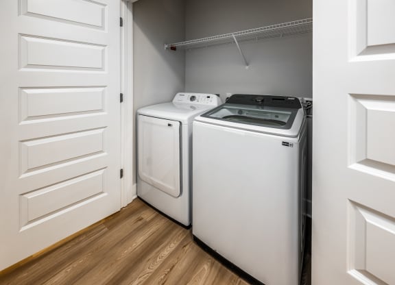 two washers and dryers in a laundry room with white doors at The Alibi at Lake Lilly, Ocoee, FL