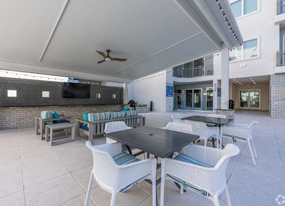 A patio with a table and chairs under a white awning.
