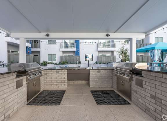 A patio with a grill and a table.