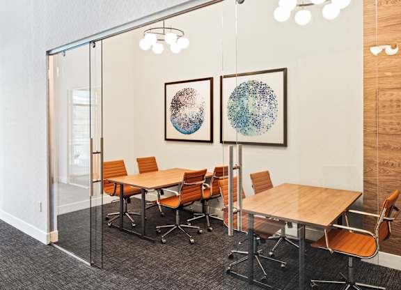 a conference room with tables and chairs and paintings on the wall at Aura Vegas Apartments, Las Vegas, 89103