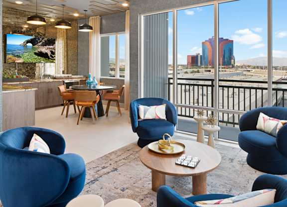 a living room with blue chairs and a view of the city at Aura Vegas Apartments, Nevada, 89103