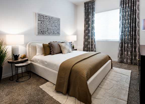 a bedroom with a bed and a window with curtains at Aura Vegas Apartments, Las Vegas, 89103
