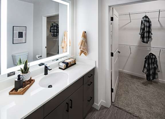 a bathroom with a sink and a mirror and a shower at Aura Vegas Apartments, Las Vegas, NV