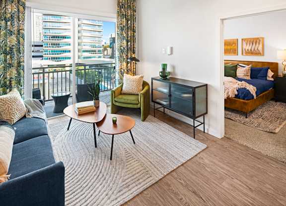 a living room with a couch and a coffee table and a bedroom with a balcony at Aura Vegas Apartments, Las Vegas