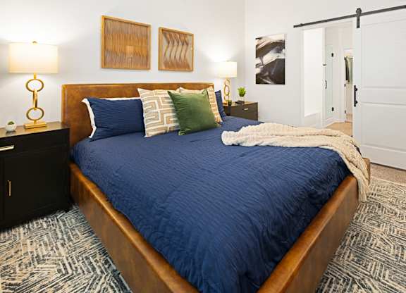 a bedroom with a large bed with blue blankets and pillows at Aura Vegas Apartments, Nevada, 89103