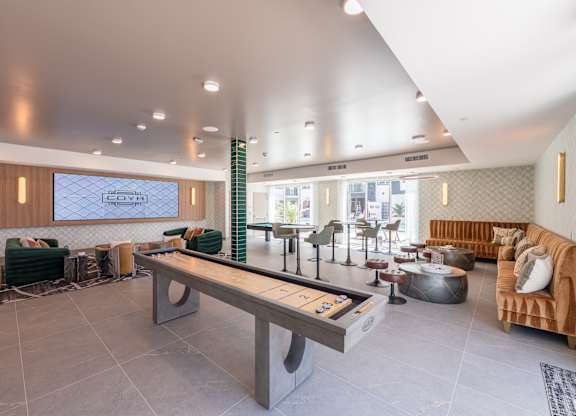 A modern waiting room with a long bench and a TV screen.