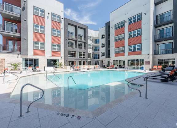 A swimming pool in front of apartment buildings.