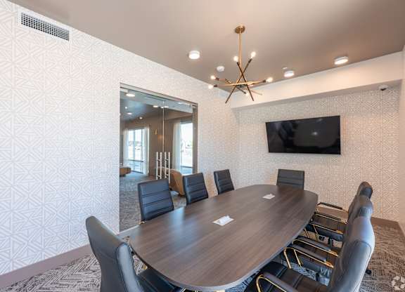 A conference room with a large table and chairs.