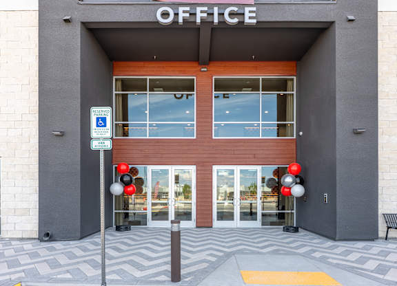 The entrance to an office building with a sign that reads "OFFICE" above the doors.