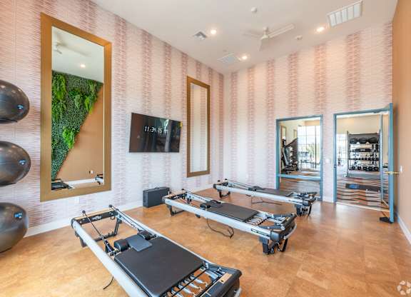 A room with pilates reformers and exercise balls.