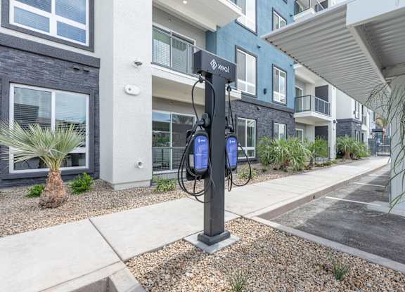 A black and white electric vehicle charging station in front of a building.