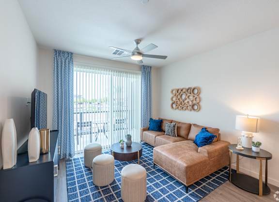 A living room with a brown couch and a blue and white tiled floor.